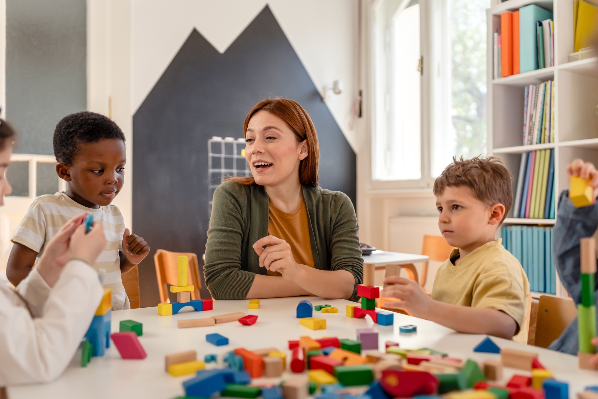 Educadora trabajando con niños y bloques didácticos para superar dificultades de aprendizaje