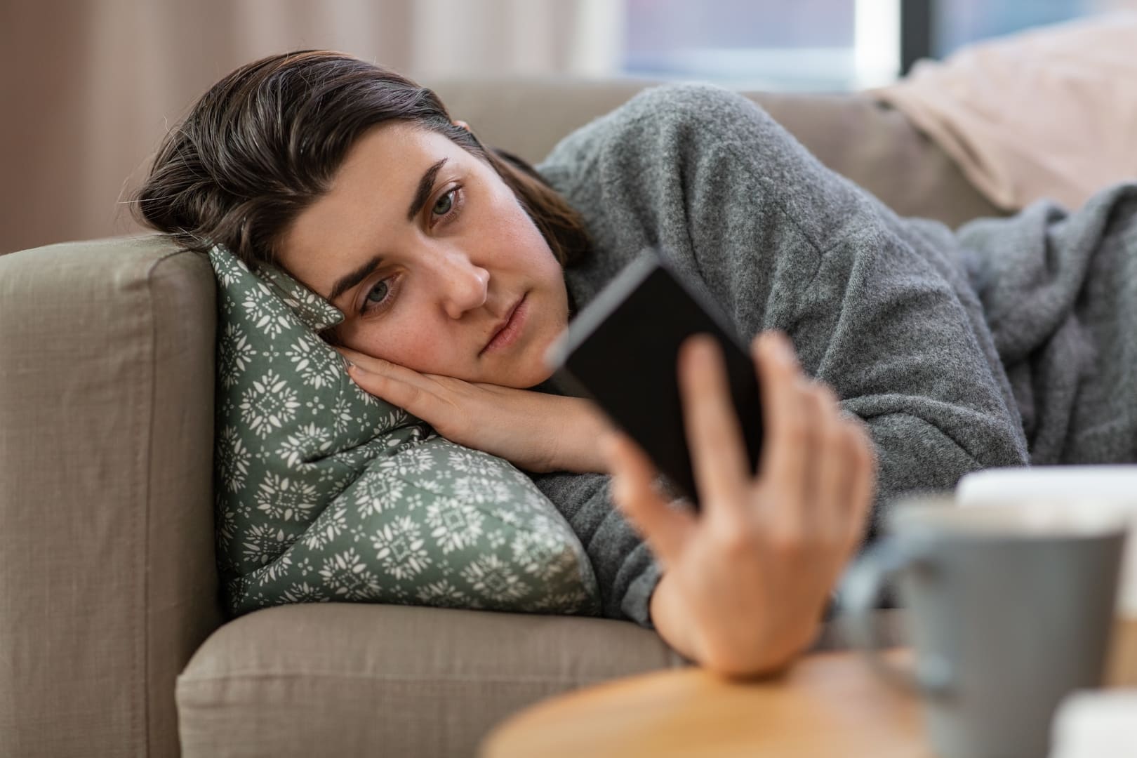 Mujer revisando su teléfono con ansiedad, caso estudiado en el programa de psicología