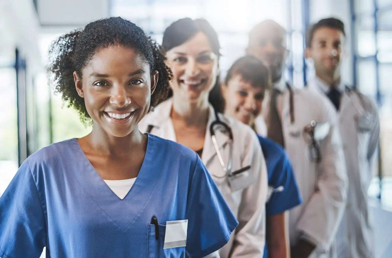 Grupo de profesionales de la salud, destacando el rol del Técnico Auxiliar en Enfermería en equipos multidisciplinarios