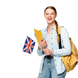 Estudiante feliz con una mochila y carpetas, sosteniendo una bandera del Reino Unido, simbolizando el aprendizaje de lenguas extranjeras y la inmersión cultural.