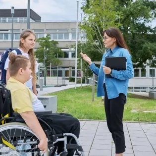 Docente de la especialización en infancia y adolescencia dialogando con estudiantes en un entorno de educación inclusiva dentro del sistema escolar.