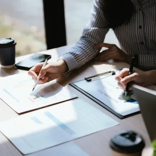 Profesionales analizando documentos financieros en una mesa, ejemplificando la diferencia entre maestria en administracion y mba.