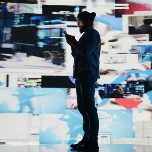 Hombre rodeado de múltiples pantallas digitales haciendo doomscrolling, concepto clave abordado en el programa de psicología