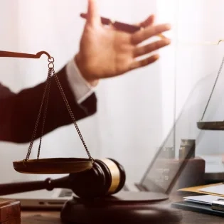 Asesores legales con balanza de la justicia y mazo durante un proceso judicial en el programa de Derecho