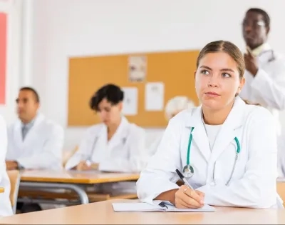 Estudiantes de la especialización en auditoría médica virtual tomando notas en clase sobre control y calidad en salud.