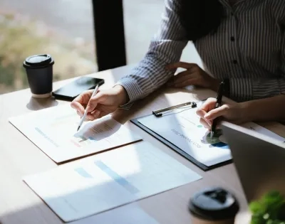 Profesionales analizando documentos financieros en una mesa, ejemplificando la diferencia entre maestria en administracion y mba.
