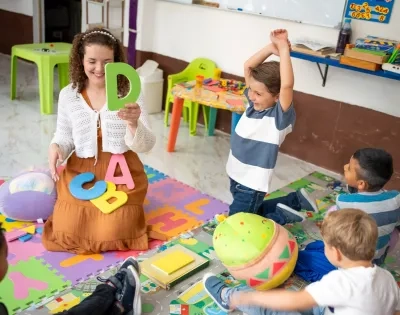 Profesora enseñando el abecedario a niños para prevenir dificultades de aprendizaje