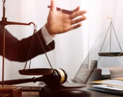 Asesores legales con balanza de la justicia y mazo durante un proceso judicial en el programa de Derecho