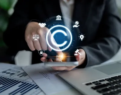 Mano interactuando con iconos legales digitales y de copyright sobre un teléfono, representando la regulación estatal y la propiedad intelectual, temas centrales para entender qué es el Derecho Administrativo. Incluye balanza de justicia y mazo.