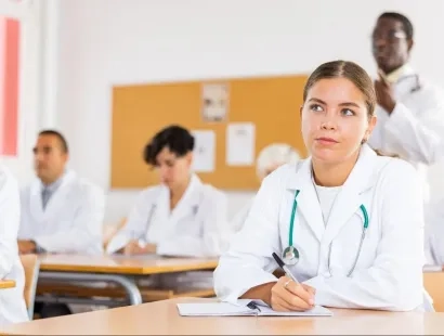 Estudiantes de la especialización en auditoría médica virtual tomando notas en clase sobre control y calidad en salud.