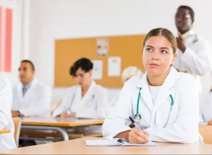 Estudiantes de la especialización en auditoría médica virtual tomando notas en clase sobre control y calidad en salud.
