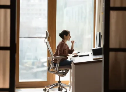Trabajadora en entorno ergonómico que fomenta la seguridad y salud en el trabajo mediante una correcta postura y diseño digital adaptado.
