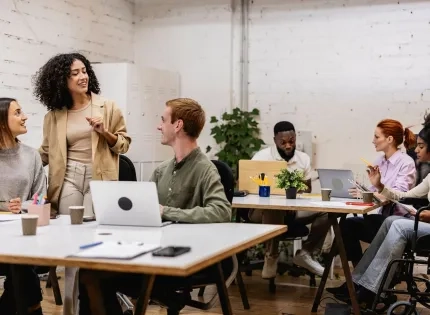 Equipo multidisciplinario en una sesión de planeación comunitaria, destacando la comunicación asertiva y la empatía como habilidades de un trabajador social.