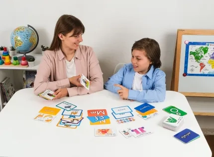 Maestra de humanidades y lengua castellana realizando actividades de lectoescritura con un niño usando tarjetas didácticas para fortalecer el aprendizaje del idioma.