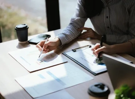 Profesionales analizando documentos financieros en una mesa, ejemplificando la diferencia entre maestria en administracion y mba.