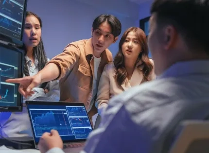 Un equipo de profesionales de la ingeniería de software colaborando frente a pantallas con gráficos y líneas de código, analizando el rendimiento de un sistema.