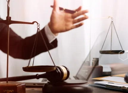 Asesores legales con balanza de la justicia y mazo durante un proceso judicial en el programa de Derecho