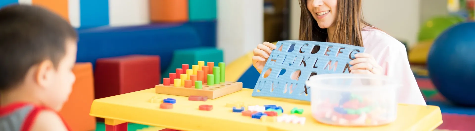 Docente en licenciatura en Educación Especial trabajando con niño en actividades de estimulación cognitiva.