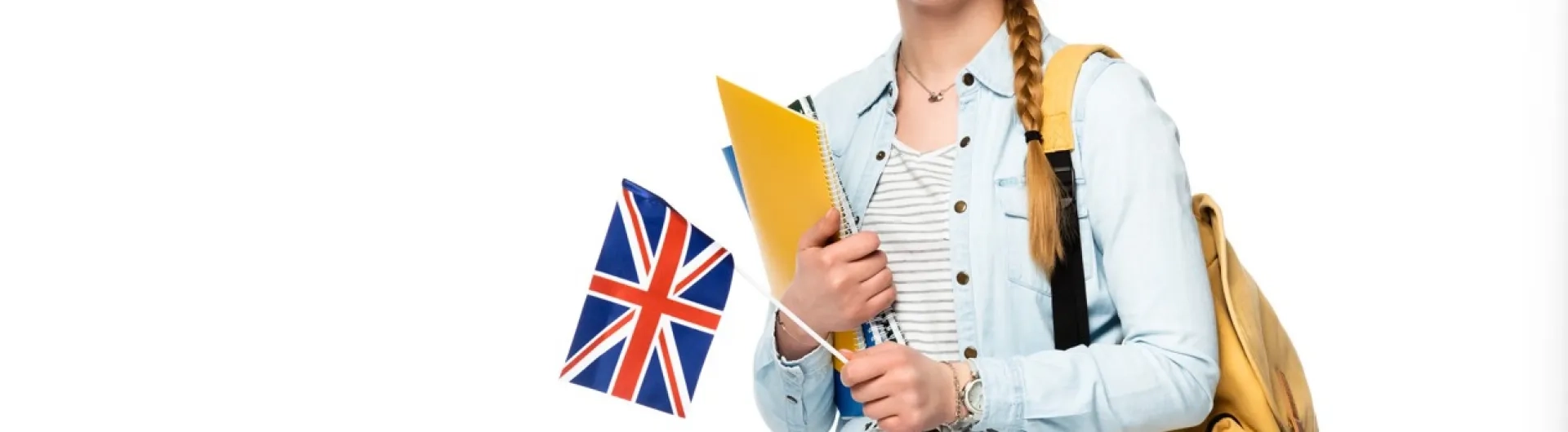 Estudiante feliz con una mochila y carpetas, sosteniendo una bandera del Reino Unido, simbolizando el aprendizaje de lenguas extranjeras y la inmersión cultural.