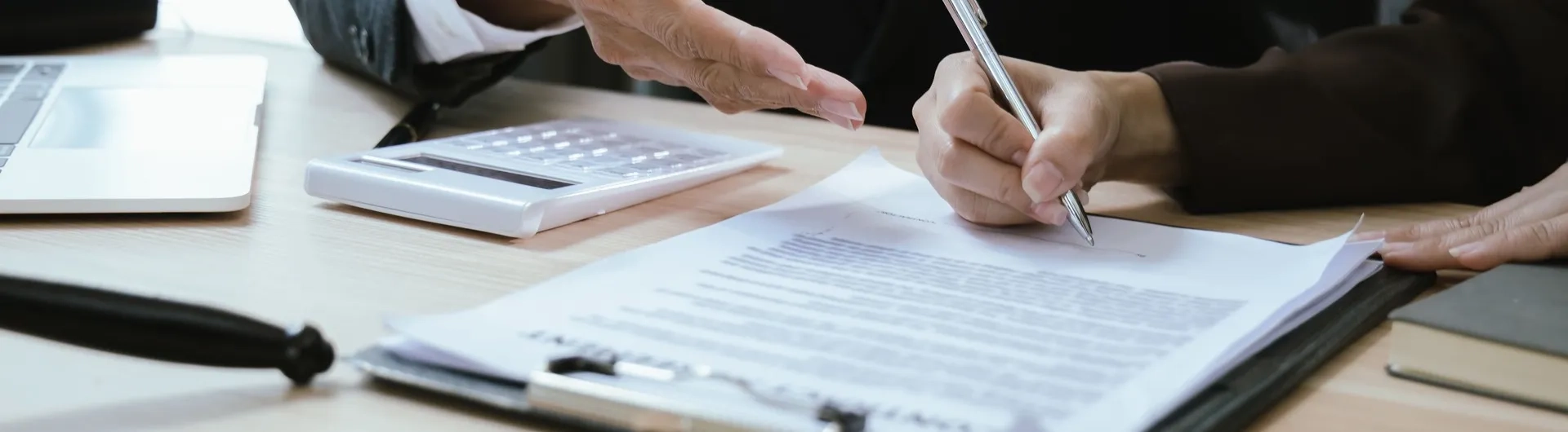 Estudiante de derecho firmando documento legal con asesoría profesional