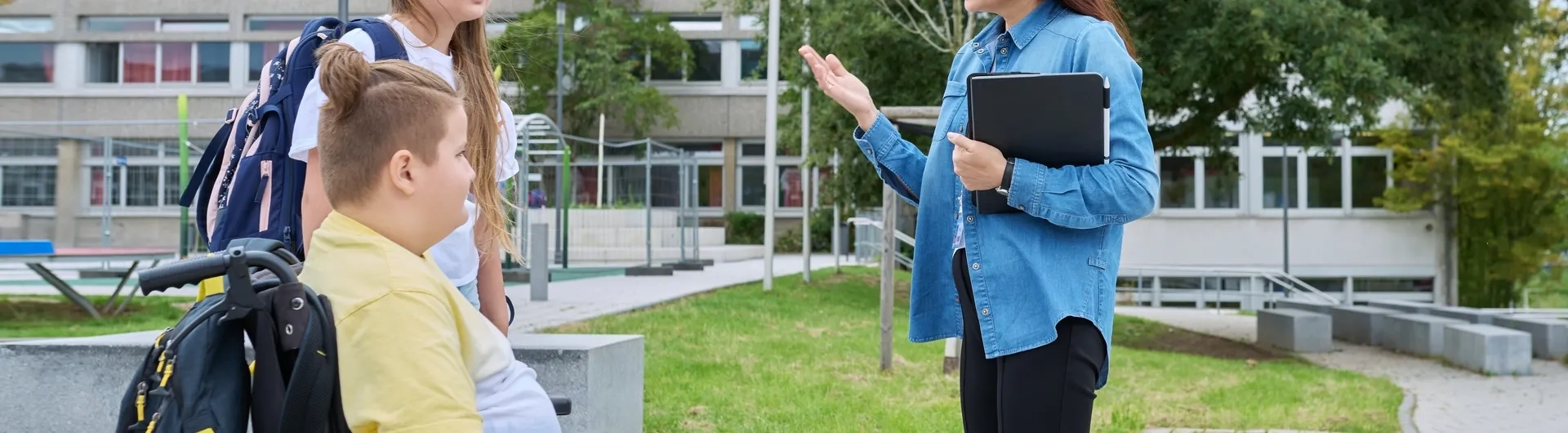 Docente de la especialización en infancia y adolescencia dialogando con estudiantes en un entorno de educación inclusiva dentro del sistema escolar.