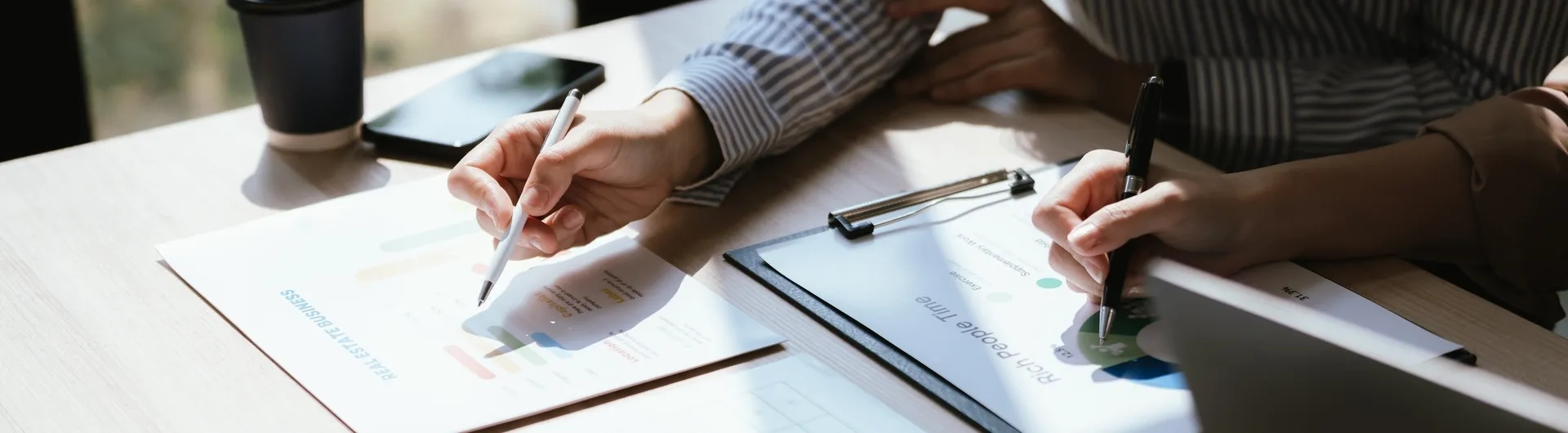 Profesionales analizando documentos financieros en una mesa, ejemplificando la diferencia entre maestria en administracion y mba.
