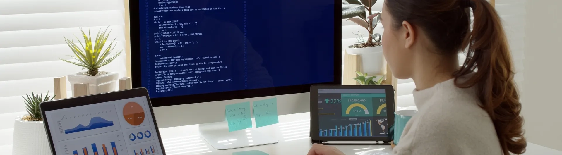 Vista trasera de una estudiante de MBA en su escritorio, rodeada de análisis de datos y gráficos empresariales, representando las competencias clave qué aprenderás en un MBA."