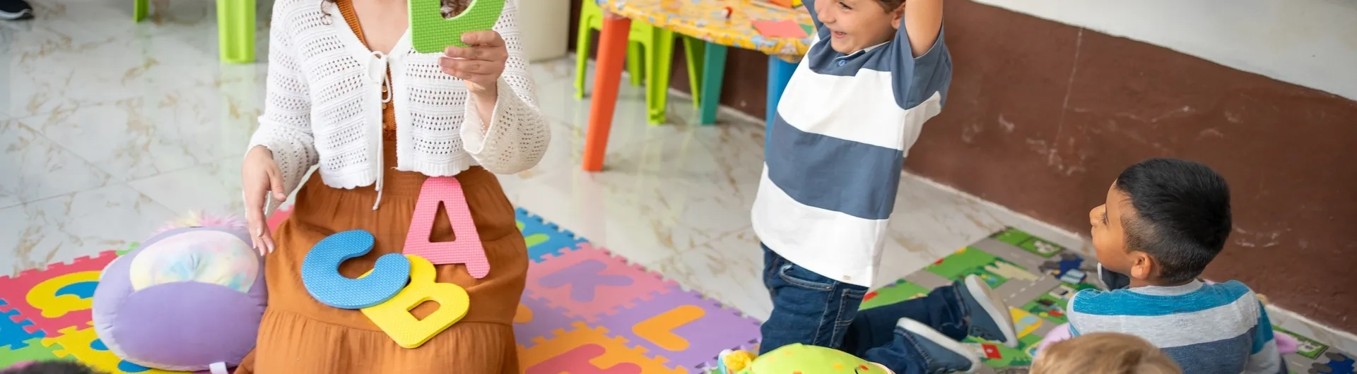 Profesora enseñando el abecedario a niños para prevenir dificultades de aprendizaje