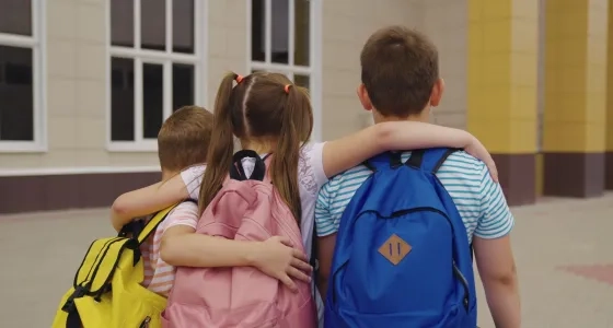 Niños caminando juntos hacia el colegio, símbolo del acompañamiento y las estrategias para el desarrollo integral en la infancia.