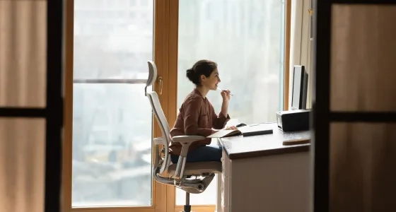 Trabajadora en entorno ergonómico que fomenta la seguridad y salud en el trabajo mediante una correcta postura y diseño digital adaptado.