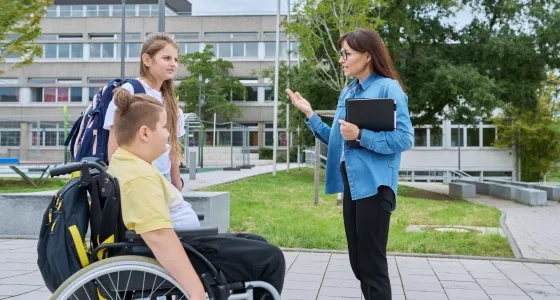 Docente de la especialización en infancia y adolescencia dialogando con estudiantes en un entorno de educación inclusiva dentro del sistema escolar.
