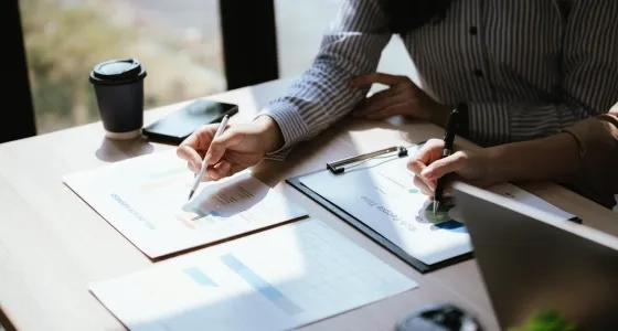 Profesionales analizando documentos financieros en una mesa, ejemplificando la diferencia entre maestria en administracion y mba.
