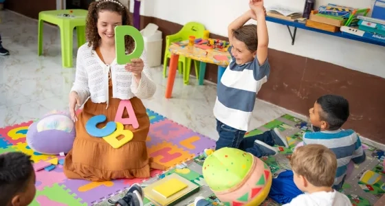 Profesora enseñando el abecedario a niños para prevenir dificultades de aprendizaje