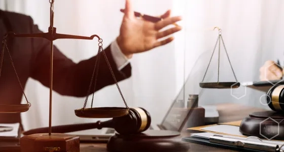 Asesores legales con balanza de la justicia y mazo durante un proceso judicial en el programa de Derecho